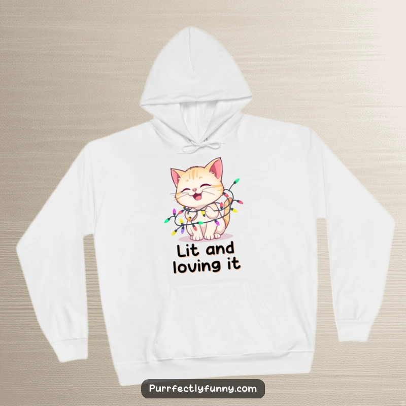 Funny hoodie showcasing a delighted cat happily tangled in colorful holiday lights, offering warmth and a humorous, festive vibe.