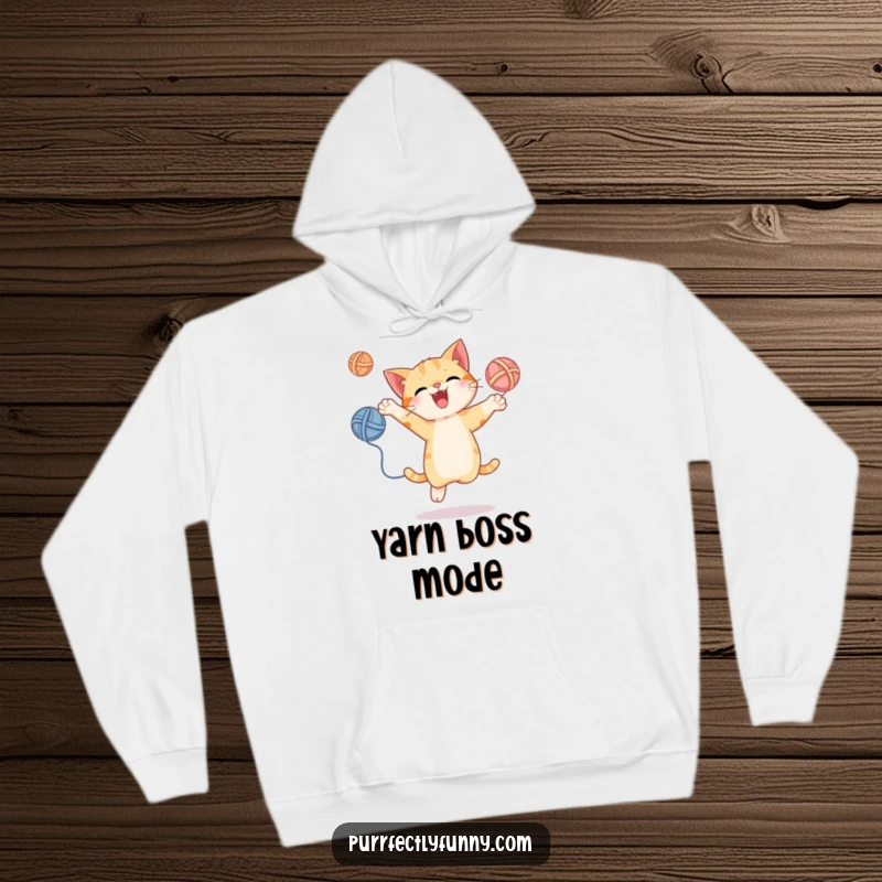 Funny hoodie featuring a cat juggling yarn balls with an energetic leap, perfect for staying warm and cheerful, a cozy gift.