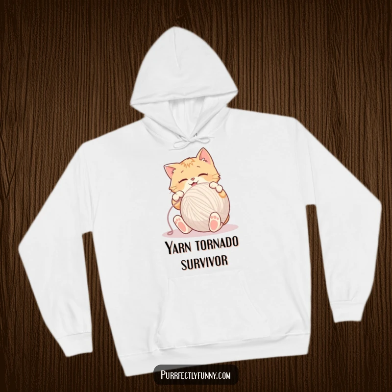 Funny Hoodie depicting an overjoyed cat enthusiastically attacking a massive ball of yarn with all its paws.